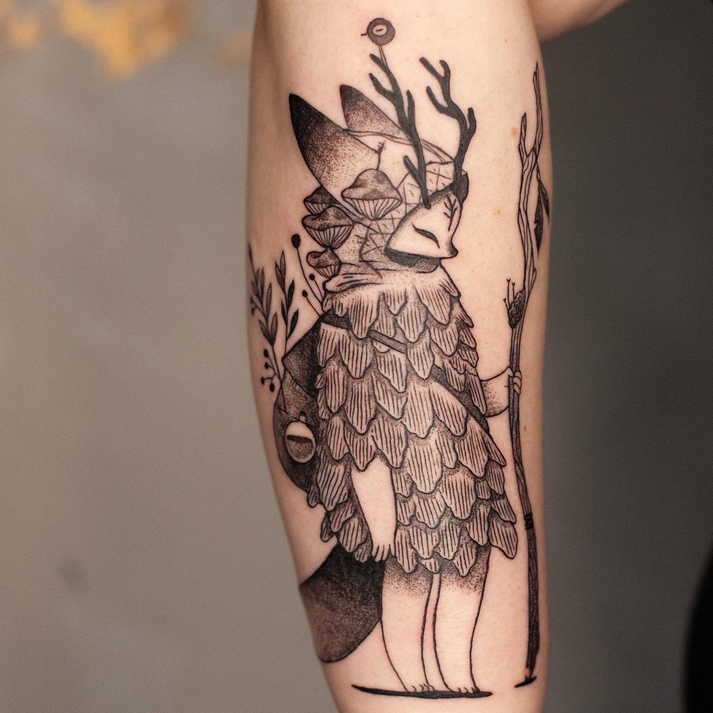 Całodniowa Sesja 6h - Luiza Kwiatkowska - Czarny tatuaż artystyczny na przedramieniu, postać zwierzęca z pióropuszem, organiczny styl, detale piór i gałęzi. - tattoo